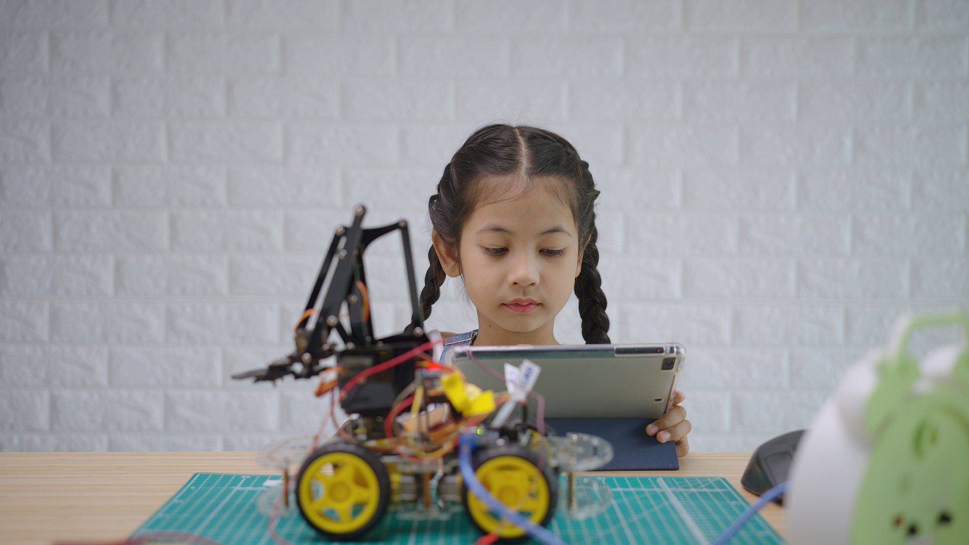 Young Girl Engaged in Robotics Programming at Home